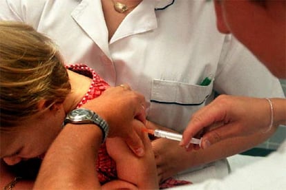 Una enfermera vacuna a una niña en un centro de salud.