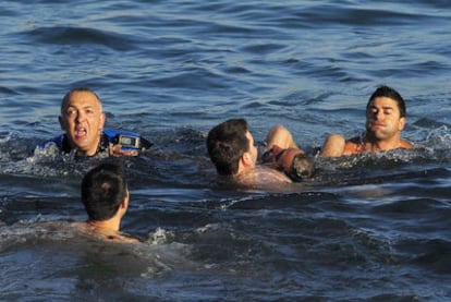 Agentes de la Policía Local de A Coruña rescatan en la playa de Orzán a un hombre moribundo.