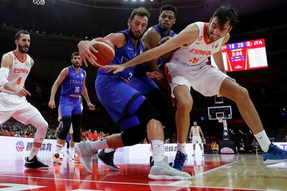 El ala pívot de España Pierre Oriola (a la derecha) intenta arrebatar el balón a los jugadores de la selección italiana Marco Belinelli (en el centro) y Jeff Brooks (segundo por la derecha).