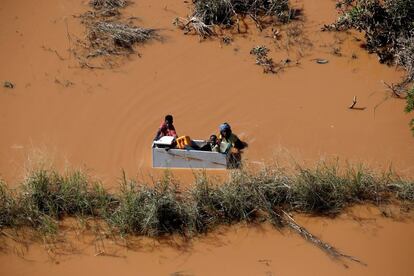 Un grupo de personas flotan sobre una nevera por las inundaciones provocadas por el paso del ciclón Idai, en Búzi (Mozambique).