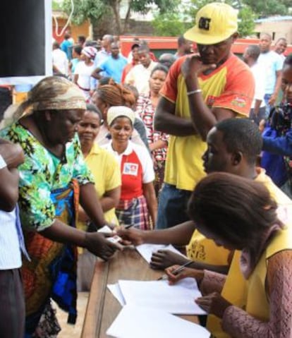 Uma eleitora apresenta sua documentação em um posto de votação em Maputo, nesta quarta-feira.