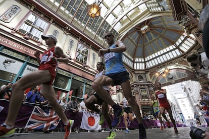 Cuatro participantes del maratón atraviesan la galería Leadenhall de Londres.