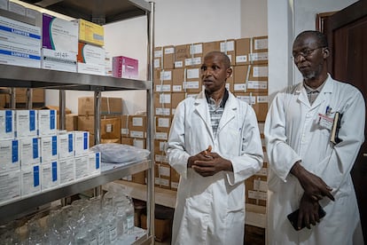 Alpha Baldé, farmacêutico-chefe (à esquerda), e o Dr. Ansoumane Kourouma, pediatra e interno do Hospital Dubreka (à direita), mostram os medicamentos restantes para o tratamento da malária.