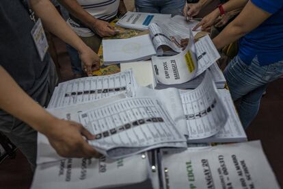 Personal electorales clasifican las listas de votantes en un recinto electoral de Manila.