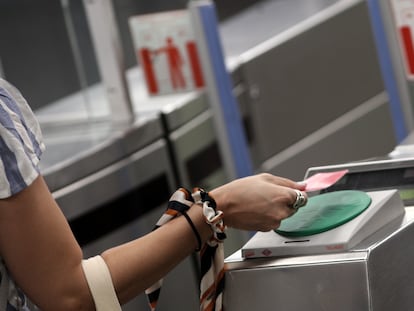 Una mujer pasa su billete en el torno del Metro Plaza de España, en Madrid.