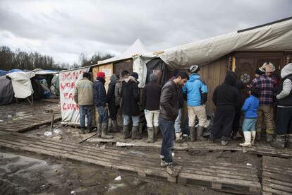 Decenas de hombres hacen cola para adquirir ropa, calzado y comida caliente que le ofrecen los voluntarios. Las recientes lluvias han inundado todo el campo donde las tiendas de campaña se sostienen en pie con dificultad. Palés industriales hacen las veces de camino para sortear el lodo.