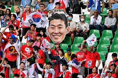 Aficionados coreanos con la cara de Son durante el partido.