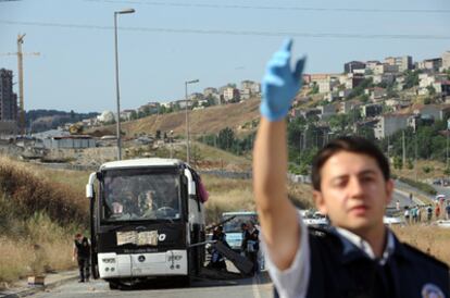 La policía turca inspecciona el autobús dañado por una bomba en el suburbio de Halkali (Estambul). Dos soldados y una niña han muerto en el atentado.