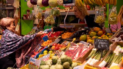 Una consumidora compra en un puesto de frutas y verduras, este martes en el mercado de Triana (Sevilla).