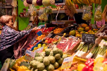 Una consumidora compra en un puesto de frutas y verduras, este martes en el mercado de Triana (Sevilla).