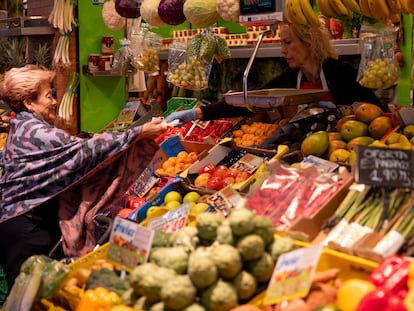 Una consumidora compra en un puesto de frutas y verduras, este martes en el mercado de Triana (Sevilla).