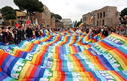 Los manifestantes avanzan hacia el Coliseo con una gran bandera con los colores del arco iris y la palabra paz, ayer en Roma.