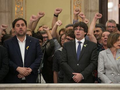 En el centro de la imagen, el expresidente de la Generalitat, Carles Puigdemont, entre el exvicepresidente, Oriol Junqueras, y la expresidenta del Parlament, Carme Forcadell, tras aprobarse la declaración de independencia, en octubre de 2017.