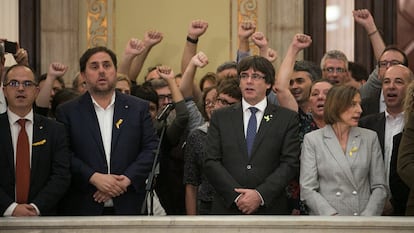 En el centro de la imagen, el expresidente de la Generalitat, Carles Puigdemont, entre el exvicepresidente, Oriol Junqueras, y la expresidenta del Parlament, Carme Forcadell, tras aprobarse la declaración de independencia, en octubre de 2017.