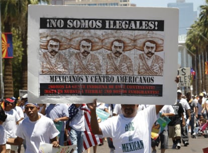 Un hispano sostiene una pancarta en contra de la nueva ley antiinmigración durante una protesta en Phoenix, Arizona.