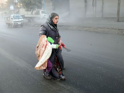 Una mujer siria y su hijo, tras un bombardeo en Alepo.