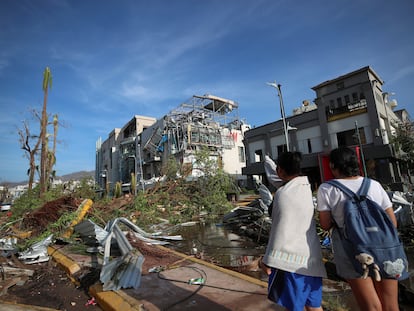 Dos mujeres miran un edificio destruido por el paso del huracán 'Otis', este jueves, en la ciudad de Acapulco.