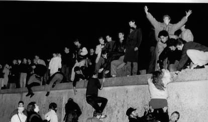 Centenares de personas escalan el Muro de Berlín, en Brandemburgo, celebrando la apertura de las fronteras alemanas.