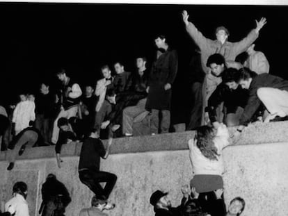 Centenares de personas escalan el Muro de Berlín, en Brandemburgo, celebrando la apertura de las fronteras alemanas.