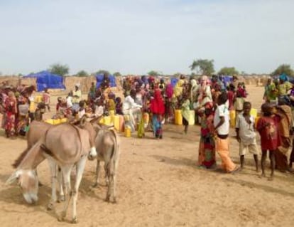 Arriba: Vista del campo de refugiados de Sayam Forage de Níger, capturada por un dron para ayudar a planificar la ayuda humanitaria. Abajo: Desplazados internos atenidos por Acnur en la región de Diffa, al sureste del Níger. Los bidones amarillos permiten transportar hasta 20 litros de agua.