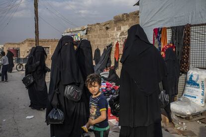 Un niño acompaña a su madre al mercado de la calle principal de uno de los mayores campamentos de desplazados del noreste de Siria. Se sospecha que los sirios e iraquíes que viven en él han jurado lealtad al Estado Islámico.
