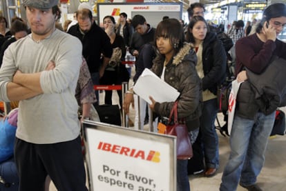 Pasajeros en una cola del servicio de atención al cliente de Iberia, ayer en la T-4 del aeropuerto de Madrid-Barajas.