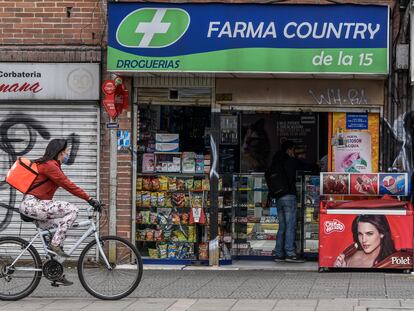 Una repartidora en bicicleta pasa frente a una farmacia en Bogotá (Colombia) en 2020.