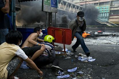 Manifestantes se refugian cerca de la zona restringida creada por el Ejército tailandés. El Gobierno ha decretado el toque de queda en distintas zonas de la capital