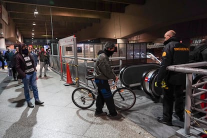 Los guardias de seguridad separan a los viajeros en las escaleras mecánicas.