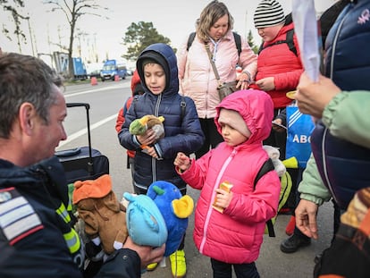Niños refugiados ucranianos reciben peluches de manos de un bombero rumano después de llegar al cruce fronterizo de Siret entre Rumania y Ucrania el 18 de abril de 2022.