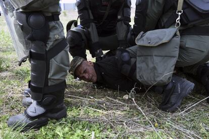 Desde el jueves, unos 700 migrantes se han concentrado en cien tiendas improvisadas alrededor del campamento de Diavatá, respondiendo a un llamamiento difundido en redes sociales que aseguraba que podrían proseguir el viaje hacia el centro de Europa, lo que ha provocado enfrentamientos con la policía griega. En la imagen, la policía antidisturbios detiene a un migrante durante los enfrentamientos, el viernes 5 de abril de 2019.