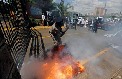 Un cartucho de gas lacrimógeno disparado por antidisturbios estalla cerca de un policía durante una manifestación de médicos en Nairobi (Kenia).