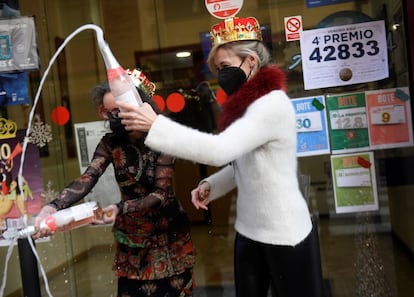 Pilar García y su socia celebran la venta del número 44469, segundo premio del sorteo extraordinario de la lotería del Niño, en el estanco situado en la calle Padre Buenaventura de Paredes, número 2, en Oviedo.