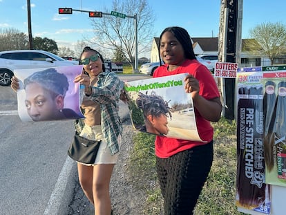 Shan'Terrius Sly-Brown, 16, left, and Shaniya Wade-Red, 15, hold signs during a protest outside of the home of Barbers Hill Independent School District superintendent, Feb. 21, 2024 in Baytown, Texas.