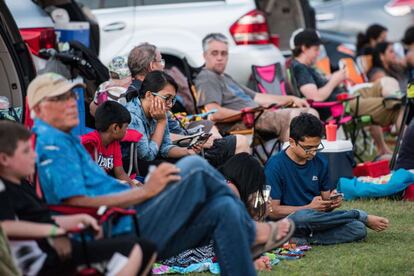 Un grupo de personas espera a ver una película al aire libre sobre los eclipses en el recinto para eventos 'Historic Columbia Speedway' el 20 de agosto en Columbia.
