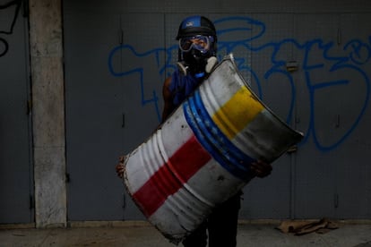 Un manifestante sostiene su escudo fabricado con un tonel de metal. 'Lucho por la libertad de expresión'.