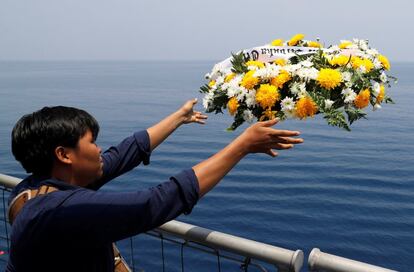 Una familiar lanza flores al mar en el lugar del siniestro del JT610, el 6 de noviembre de 2018.