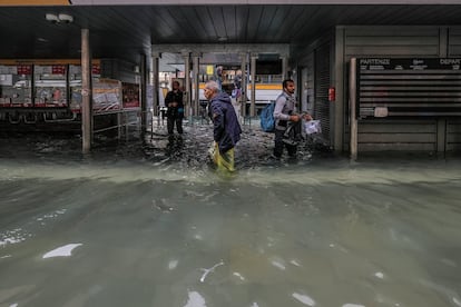 Vários pessoas tentam caminhar em frente à estação de trem em Veneza. Além das inundações, os fortes ventos do temporal provocaram a queda de dezenas de árvores em toda a Itália.