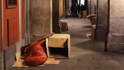 Una persona sin hogar durmiendo en los soportales de la Plaza Mayor de Madrid.