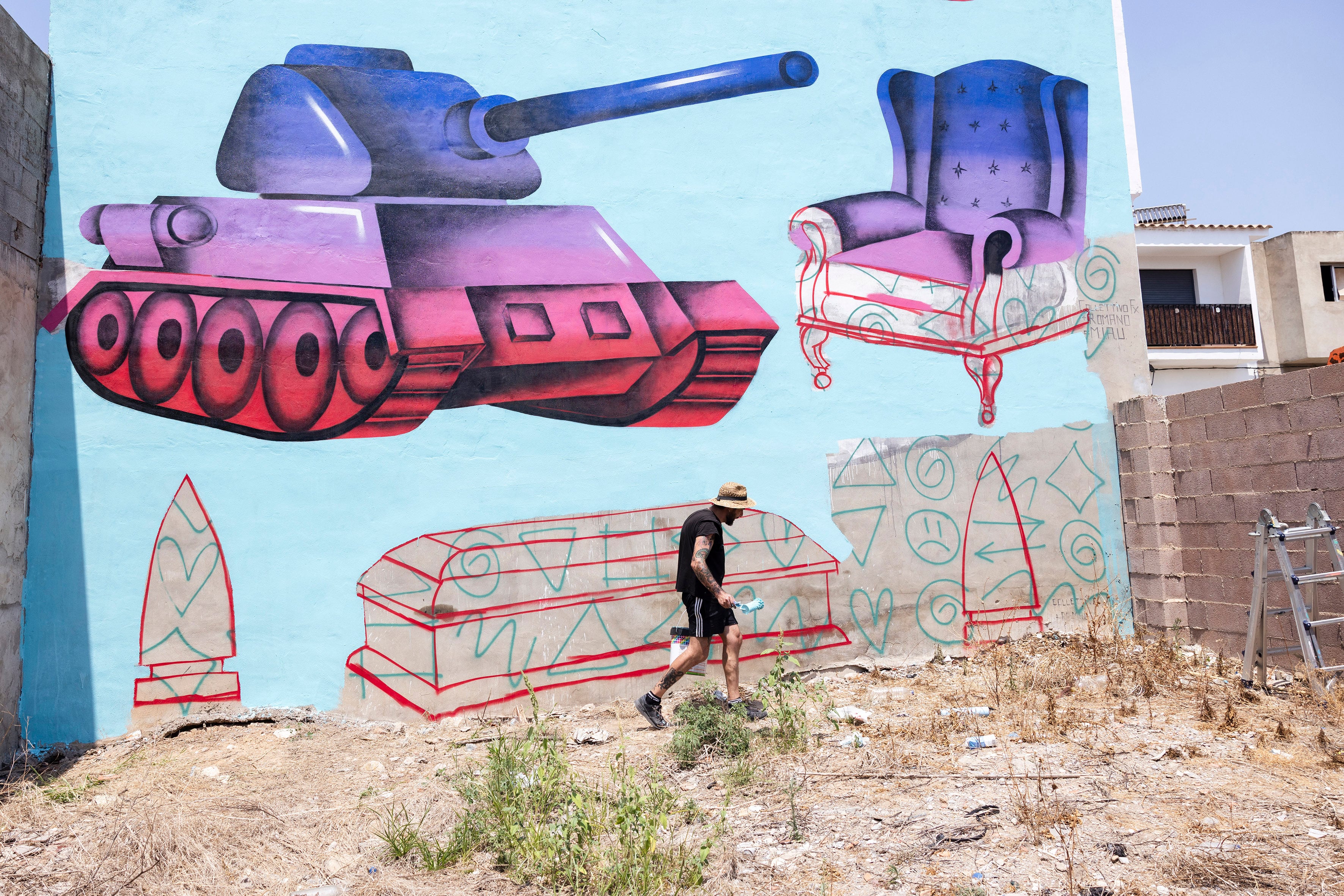 El artista Digo Diego pinta un mural en Fanzara, en Castellón, durante el festival de arte urbano MIAU.