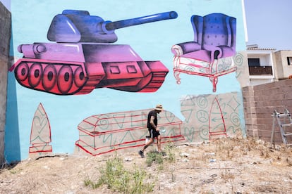 El artista Digo Diego pinta un mural en Fanzara, en Castellón, durante el festival de arte urbano MIAU.