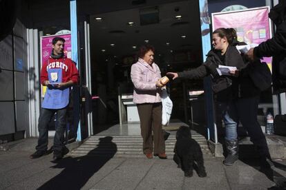 Voluntarios del banco de alimentos reciben una donación de azúcar a las afueras de un supermercado.