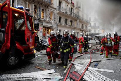 La explosión despertó a muchos vecinos que aprovechaban la mañana del sábado para dormir. Dos horas después, los bomberos seguían intentando apagar el incendio. En la imagen, los bomberos evacúan a una persona herida en la explosión.