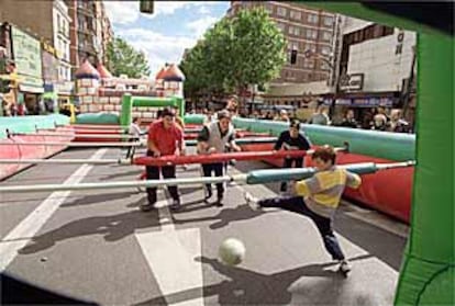 Varios niños jugaban ayer dentro de un futbolín gigante instalado en la calle de Bravo Murillo.