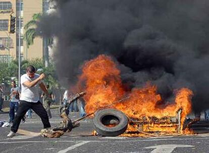 Un manifestante aviva el fuego de una barricada durante la protesta de ayer contra la reforma constitucional en Valencia, al norte de Venezuela.