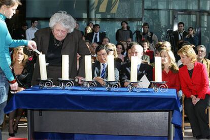 La superviviente del holocausto Hata Bohrer enciende una vela durante el acto celebrado en la Asamblea de Madrid.