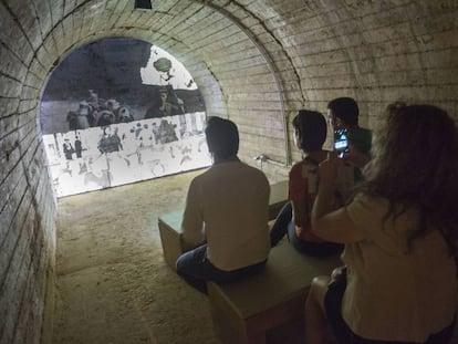 Visitantes del refugio de Castellón ante uno de los documentales que se proyectan en el interior.