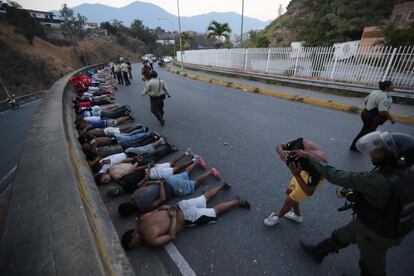 Un grupo de personas son detenidas por las fuerzas de seguridad bolivarianas tras el saqueo a algunos negocios durante un apagón en Caracas. 