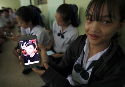 Una estudiante tailandesa muestra una fotografía de su compañero de clase, Duangpetch Promthep, quien se encontraba atrapado en la cueva, en el distrito de Mae Sai, Chiang Rai, el 11 de julio de 2018.  