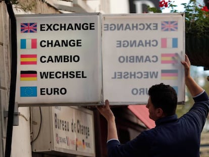 Un trabajador coloca un cartel de cambio de moneda en Gibraltar.